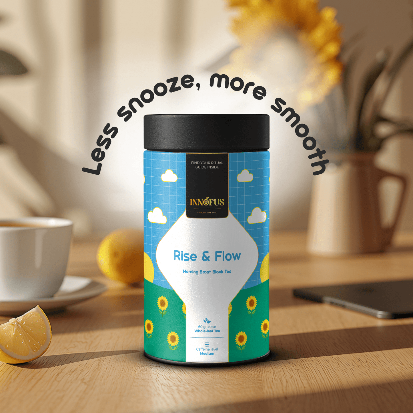 Rise & Flow morning boost black tea by Innofus, medium caffeine loose leaf in blue sunflower tin, “Less snooze, more smooth” tagline, lemon wedges, cup and floral vase on morning sunlit table.